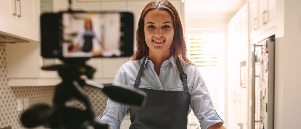 A small business owner wearing an apron recording a video