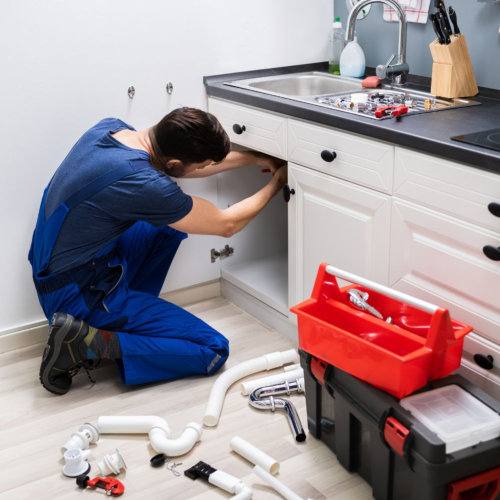 Plumber fixing a sink - web design for plumbers